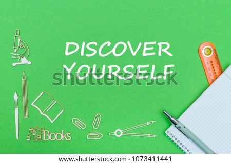 concept school, text discover yourself, school supplies wooden miniatures, notebook with ruler and pen on green backbord