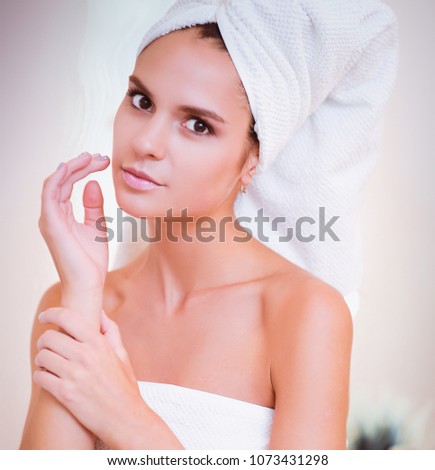 Young attractive woman standing in front of bathroom mirror