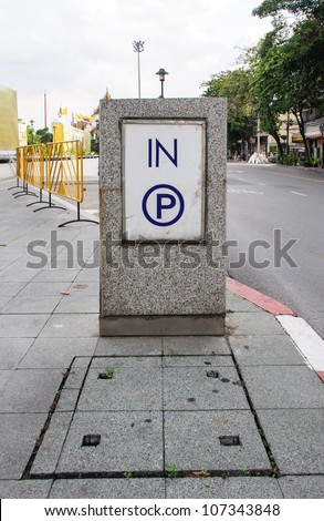 Modern parking sign on the pavement of urban street.