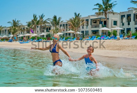 mom and daughter indulge on the beach