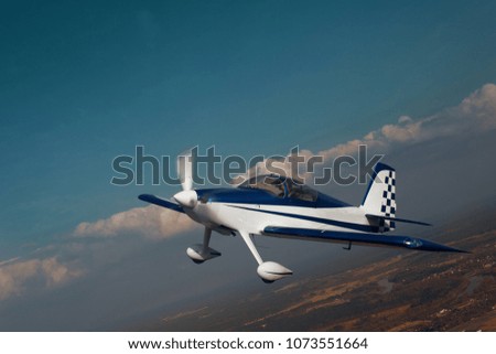Small airplane flying over the land. Air to air photo