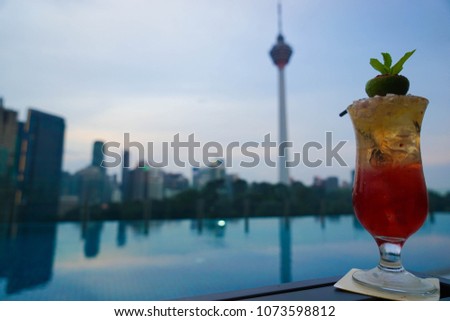 Rooftop cocktail in Kuala Lumpur with skyline views behind