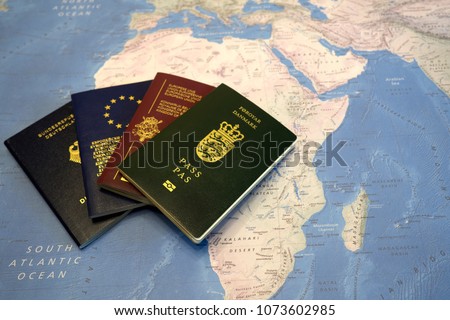 Passports of citizens of EU countries, located in the form of a fan, in the background of a map of the world