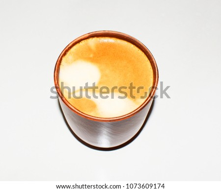 Photo of a cup of coffee. A saturated coffee color with an airy foam and a bright aroma.