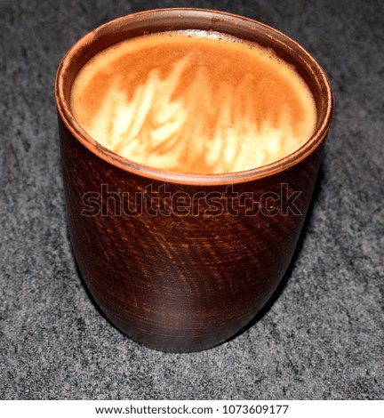 Photo of a cup of coffee. A saturated coffee color with an airy foam and a bright aroma.