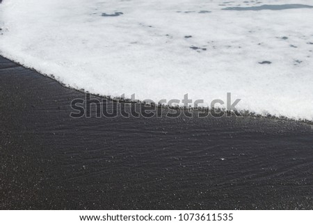 beach black sand around white water 