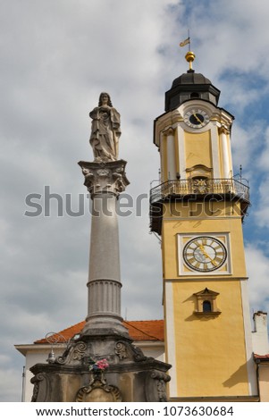 Virgin Mary statue on Baroque Marian column with Clock Tower in background. Banska Bystrica, Slovakia.