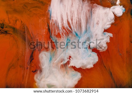 Color paint drops in water. Ink swirling underwater. Cloud of silky ink collision on orange background. Colorful abstract smoke explosion animation. Close up camera view.