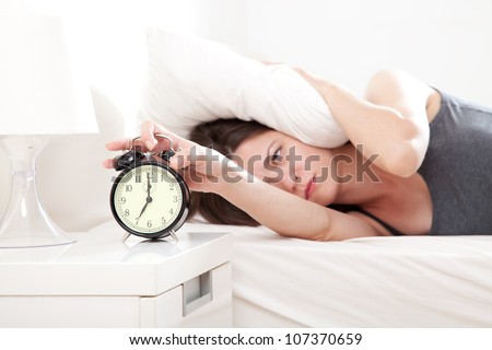 Young woman getting stressed about waking up too early, shallow depth of field, focus on foreground Royalty-Free Stock Photo #107370659