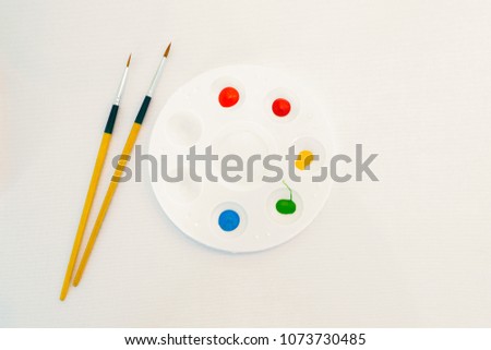 Multicolored watercolor in a round white plastic tray.