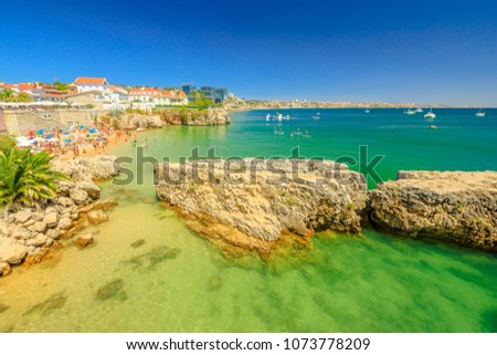 Scenic landscape of Praia da Rainha, small beach with cliffs in Cascais center, Portugal. Aerial view of Lisbon Coast. People sunbathing and swimming in turquoise sea during summer holidays.Copy space Royalty-Free Stock Photo #1073778209