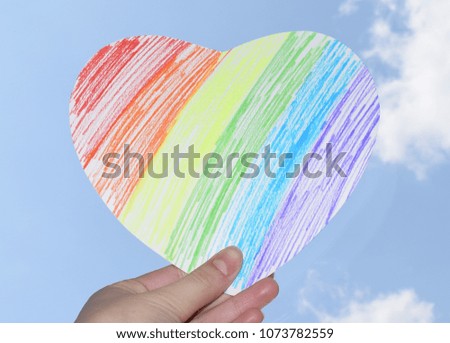 Photo of a rainbow heart against the sky. Symbols of LGBT people.