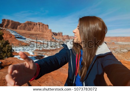 Female traveler takes self-picture in the Arches National Park, Utah, USA.