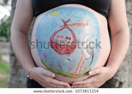 belly of a pregnant woman painted. Stork