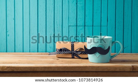 Happy Fathers day concept with coffee cup, mustache and gift box over wooden background Royalty-Free Stock Photo #1073814926
