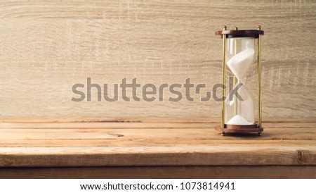 Hourglass on wooden table. Countdown to a deadline concept