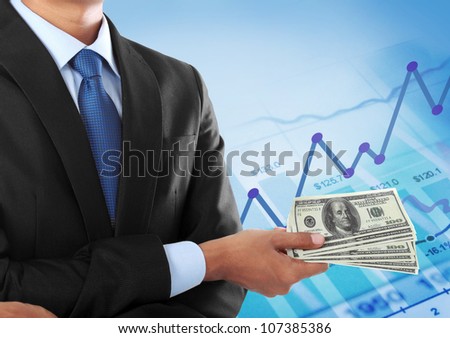 business man holding money on graphic chart background