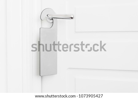Door knob with empty label on a door handle for your text. Empty white flyer mockup hang on door handle. Leaflet design on entrance doorknob. Dont disturb sign. Hotel room clear hanger. blank