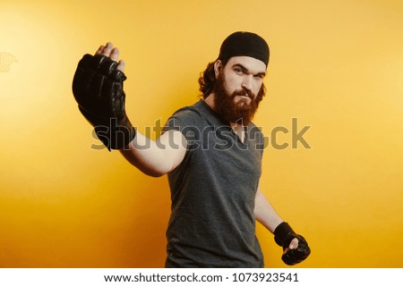 Fighter in black gloves. Confidence man. Yellow background. Winner.
