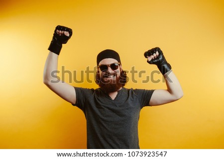 Fighter in black gloves. Confidence man. Yellow background. Winner.