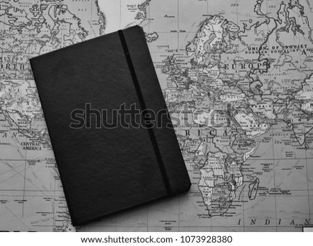 Black leather notebook on a world map background