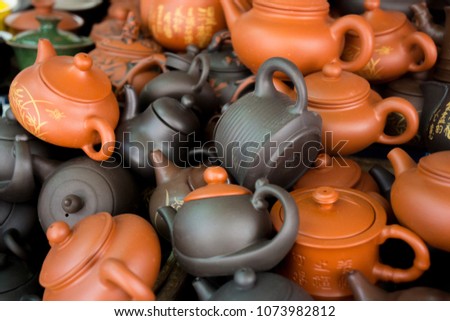pattern brown and orange china tea pot in the market. A simple picture showing a clay teapot.Selective focus.
