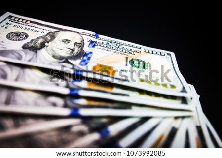 Banknotes 100 dollars cash on black background texture. It' s symbol of wealth investment.