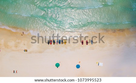 Aerial : Overhead  of people enjoying the summer at sand  beach ,waves breaking against the coast line