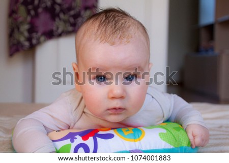 A portrait of an adorable blue-eyed baby learning to crawl
