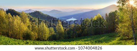 Dawn in the Altai Mountains, summer landscape, green slopes and forest, view from the mountain Royalty-Free Stock Photo #1074004826