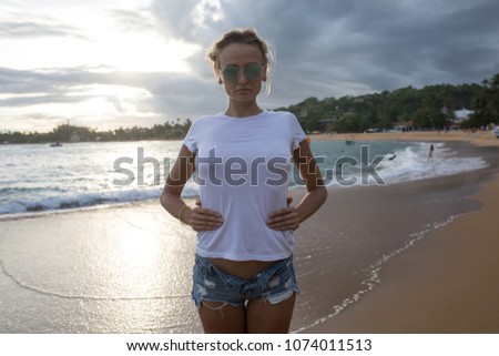 Beautiful young woman in a white t-shirt on the beach. Mock-up.