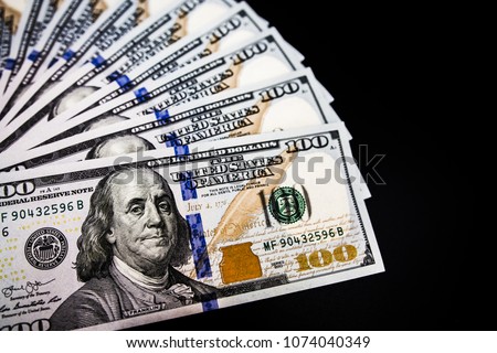 Banknotes 100 dollars cash on black background texture. It' s symbol of wealth investment.