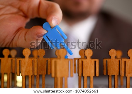 Man arm in suit take little plastic toy figure out of crowd closeup. Fire one worker hr job shift head hunter inspector rare disease unit dismissal retire lgbt media virus epidemic success concept Royalty-Free Stock Photo #1074052661
