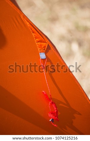 Closeup of details of an orange camping tent. Bright orange color.  Shallow depth of field.