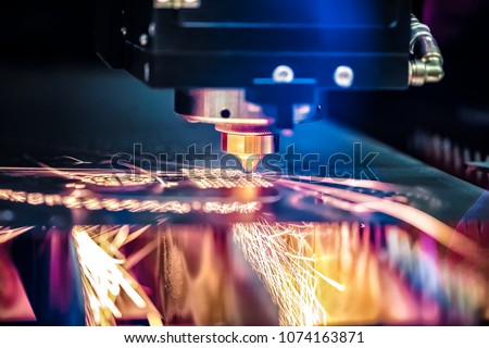 CNC Laser cutting of metal, modern industrial technology. Small depth of field. Warning - authentic shooting in challenging conditions. Royalty-Free Stock Photo #1074163871