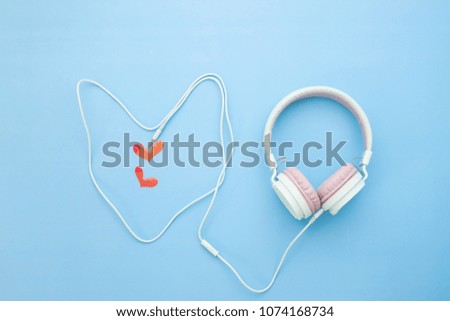 Pastel color headphone heart shape with little red heart on blue color background, Love emotion