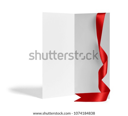 close up of a  blank folded leaflet or a desktop calendar with ribbon on white background 