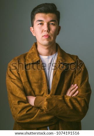 Young man wearing white t shirt and brown nubuck jacket in studio