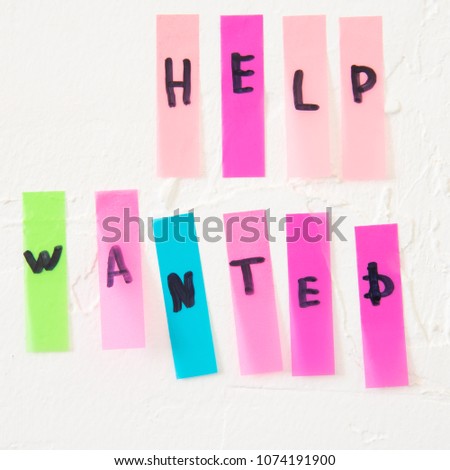 sticker message on rough white wall, help wanted
