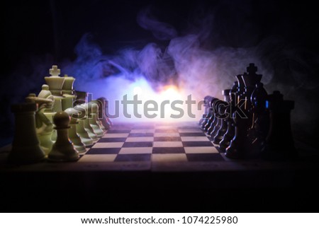 Chess board game concept of business ideas and competition and strategy ideas concept. Chess figures on a dark background with smoke and fog. Business leadership and confidence concept. Selective focus
