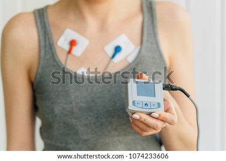 Woman wearing holter monitor device for daily monitoring of an electrocardiogram. Treatment of heart diseases Royalty-Free Stock Photo #1074233606