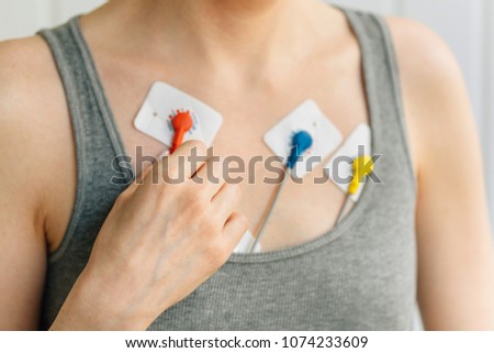 Woman wearing holter monitor device for daily monitoring of an electrocardiogram. Treatment of heart diseases Royalty-Free Stock Photo #1074233609