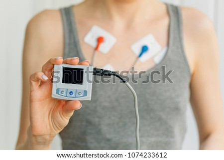 Woman wearing holter monitor device for daily monitoring of an electrocardiogram. Treatment of heart diseases Royalty-Free Stock Photo #1074233612