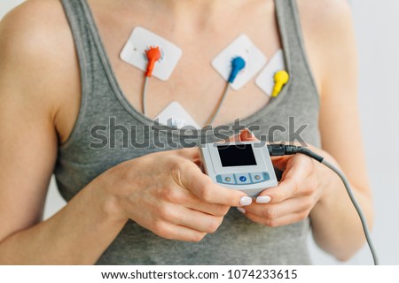 Woman wearing holter monitor device for daily monitoring of an electrocardiogram. Treatment of heart diseases Royalty-Free Stock Photo #1074233615