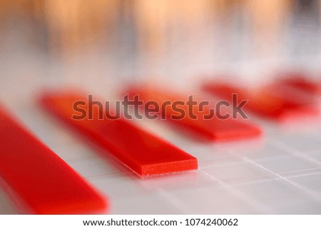 Red plastic graph columns on table closeup