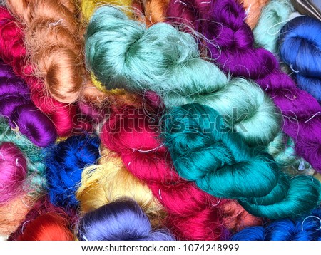 Colorful silk abstract line thread thailand bundle and dyed with mix of red, purple, deep blue, deep green, light green, yellow, pink and orange take picture from IphoneX Royalty-Free Stock Photo #1074248999