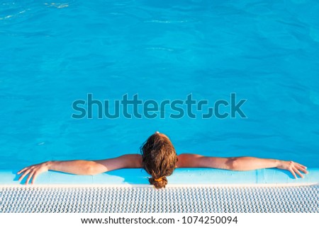 Young woman relaxing in the pool. Copy space