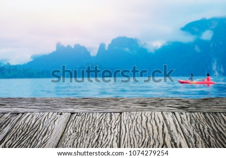 old wooden table for put something on it and blurry background is the sea.