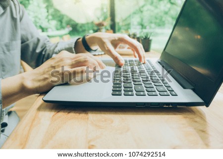 businessman using laptop and smart phone for work, analyze marketing strategy with statistic graph and notebook on wooden desk.stock trading analysis.