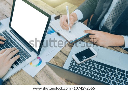 business team analyzing marketing strategy with smart phone, tablet, notebook, and laptop on wooden desk, Freelance work at home office.Team work and helping hand